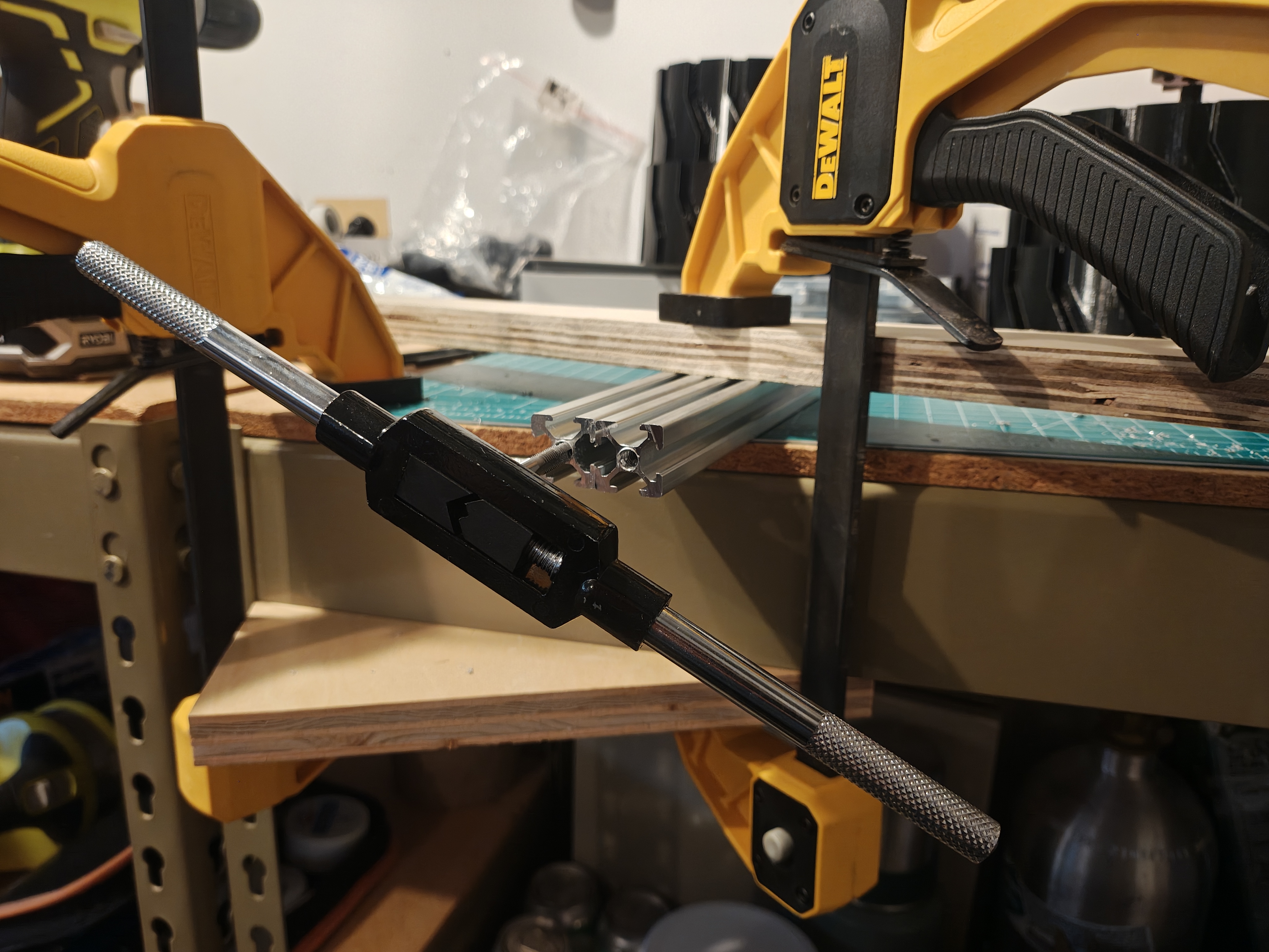 Hand holding a tap tool inserted into aluminum extrusion, cutting threads into the end