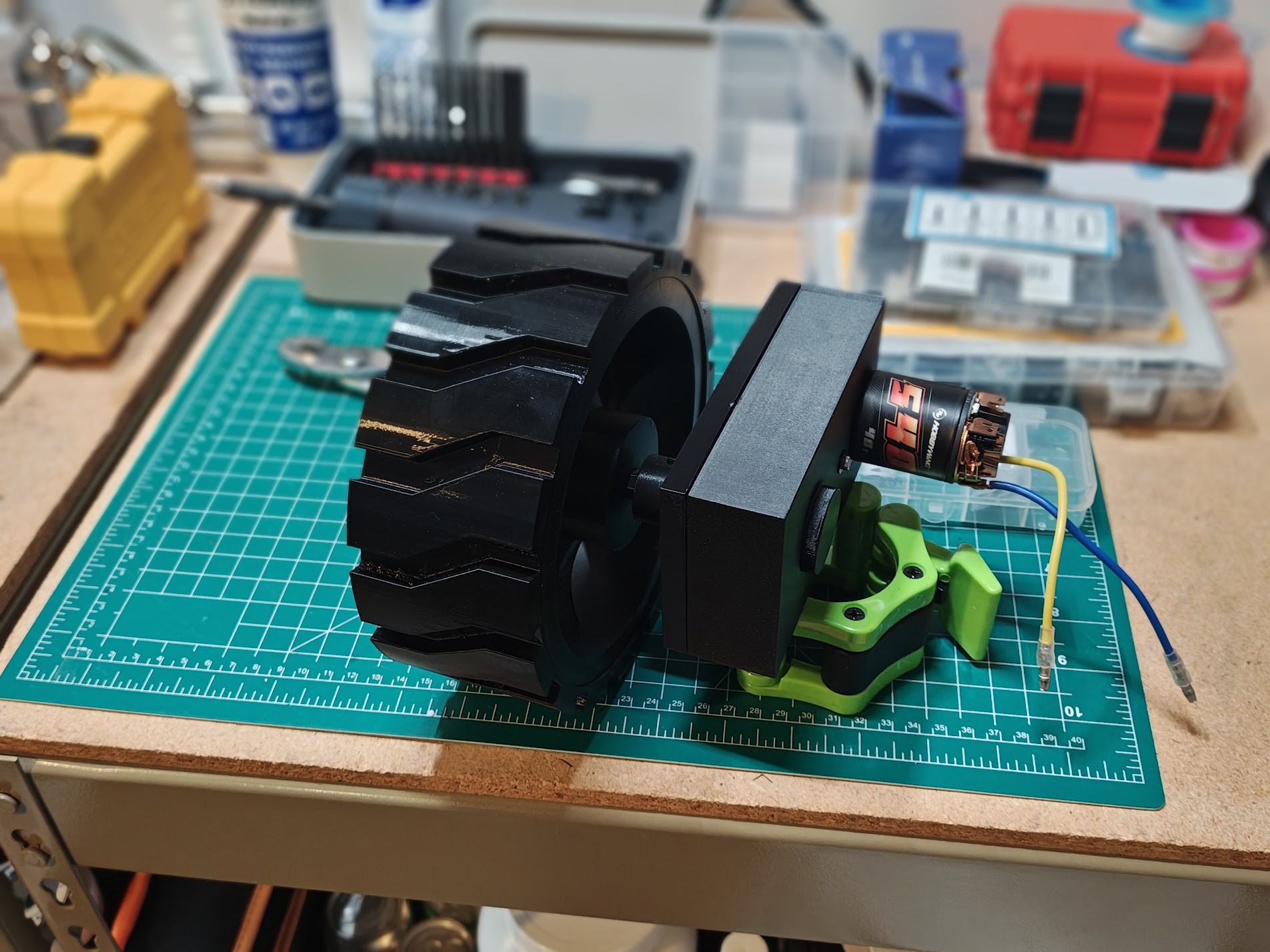 Black gearbox with 540 brushed motor attached to a black wheel with knobby tire