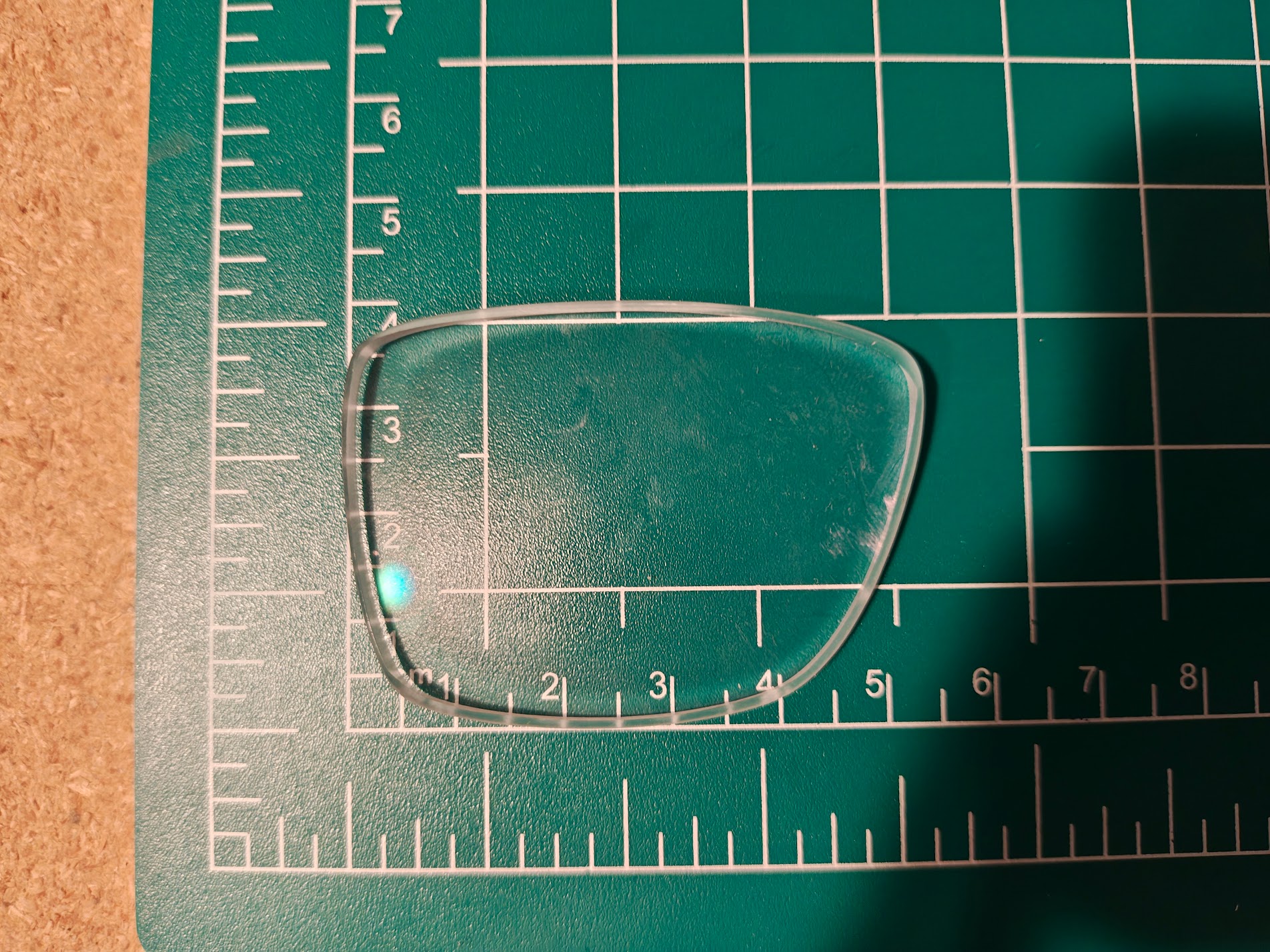 Prescription lens on a cutting mat being measured