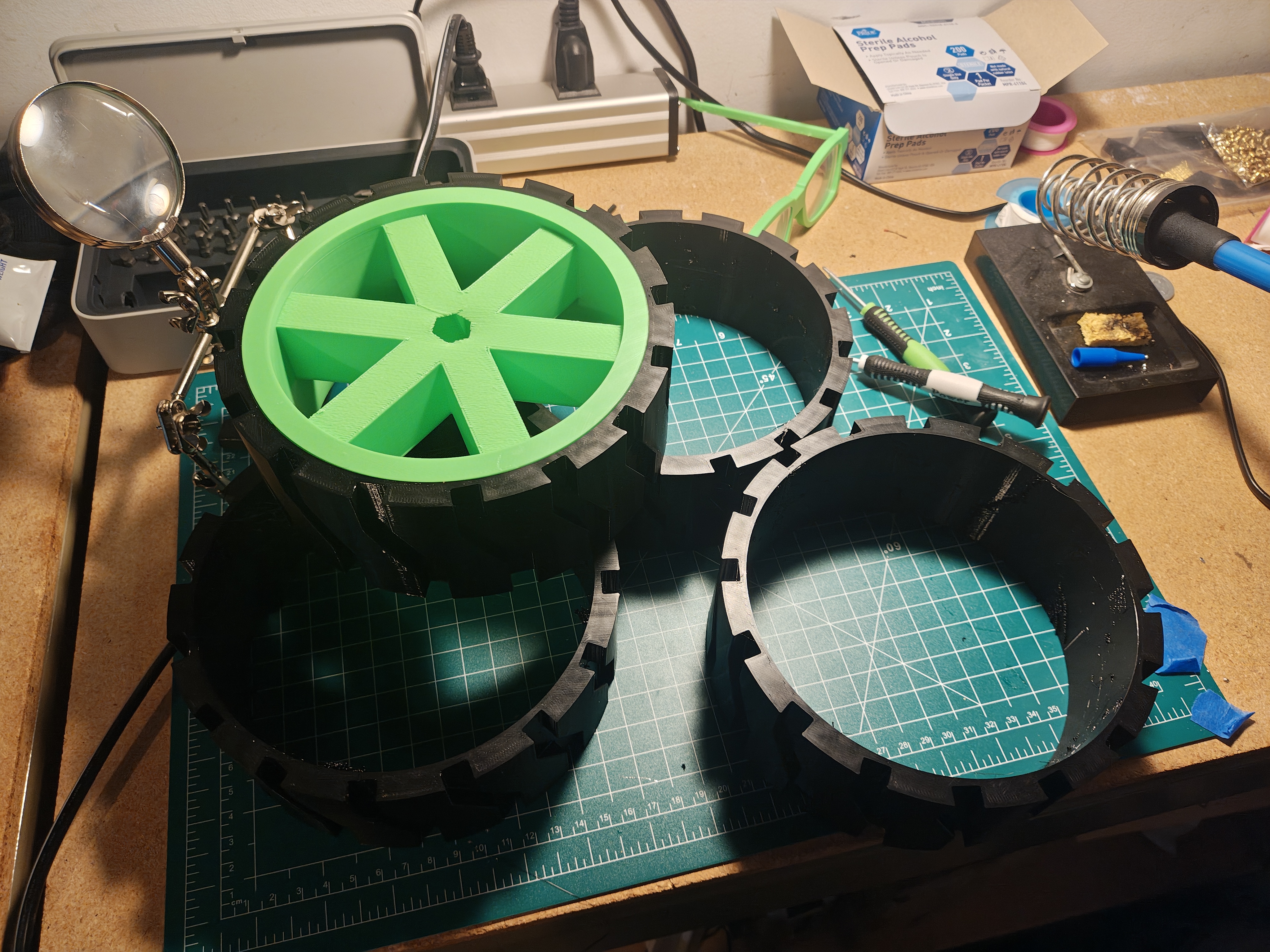 Several wheel hubs and black TPU tires spread out on workbench for test fitting