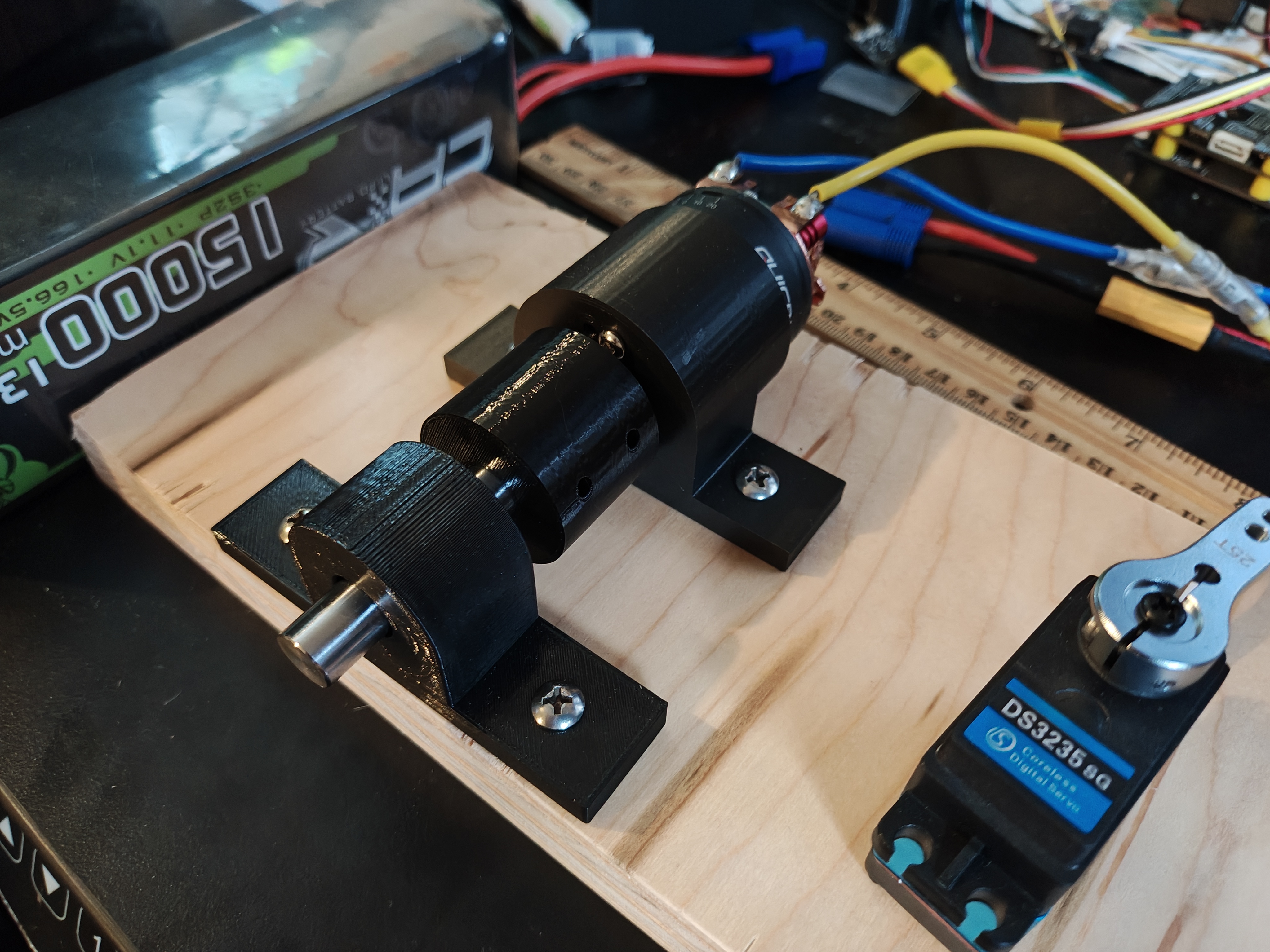 Motor mounted in white 3D-printed housing with bearing block on workbench