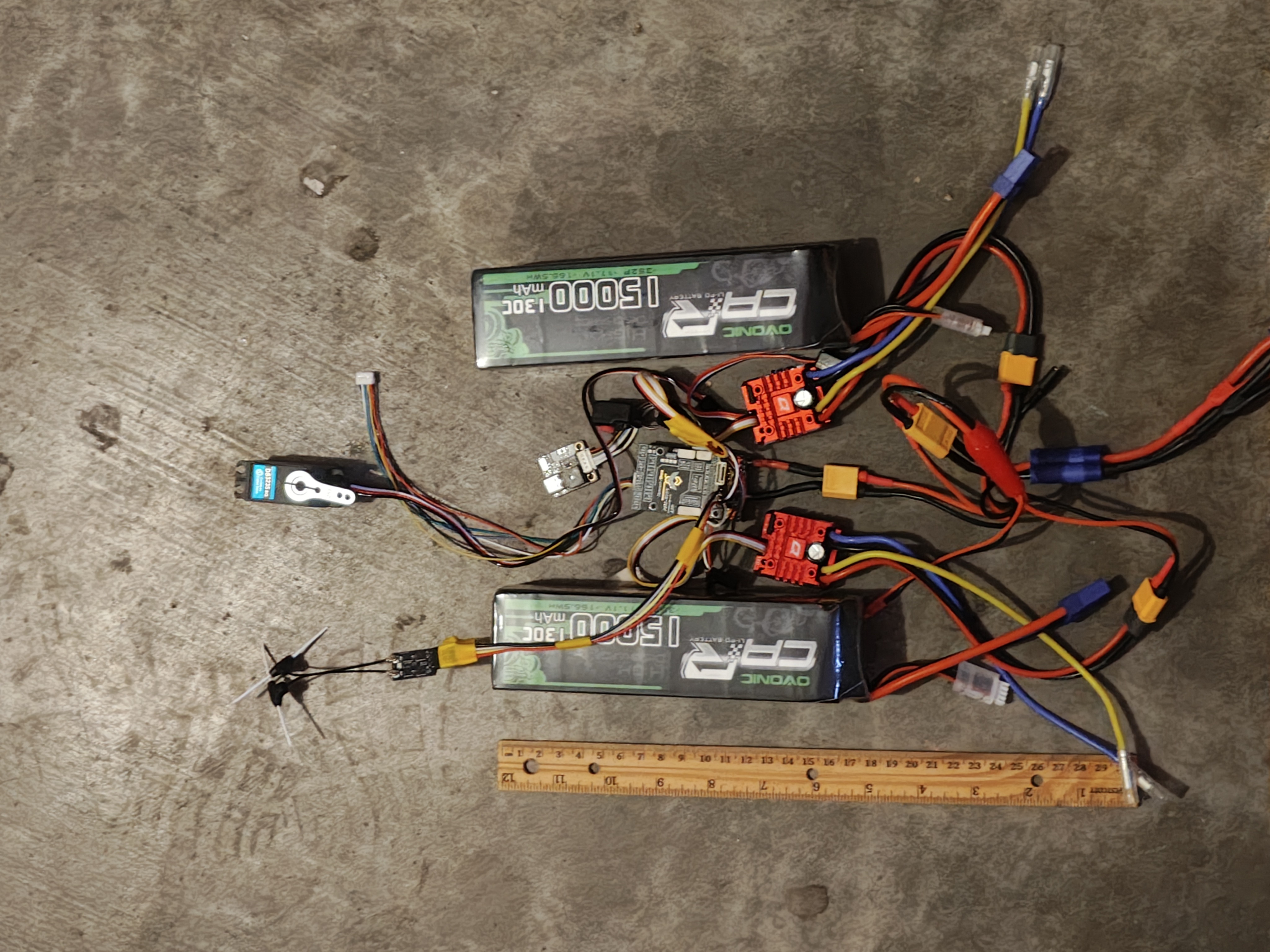 Batteries, ESCs, and wiring spread out on concrete garage floor for sizing