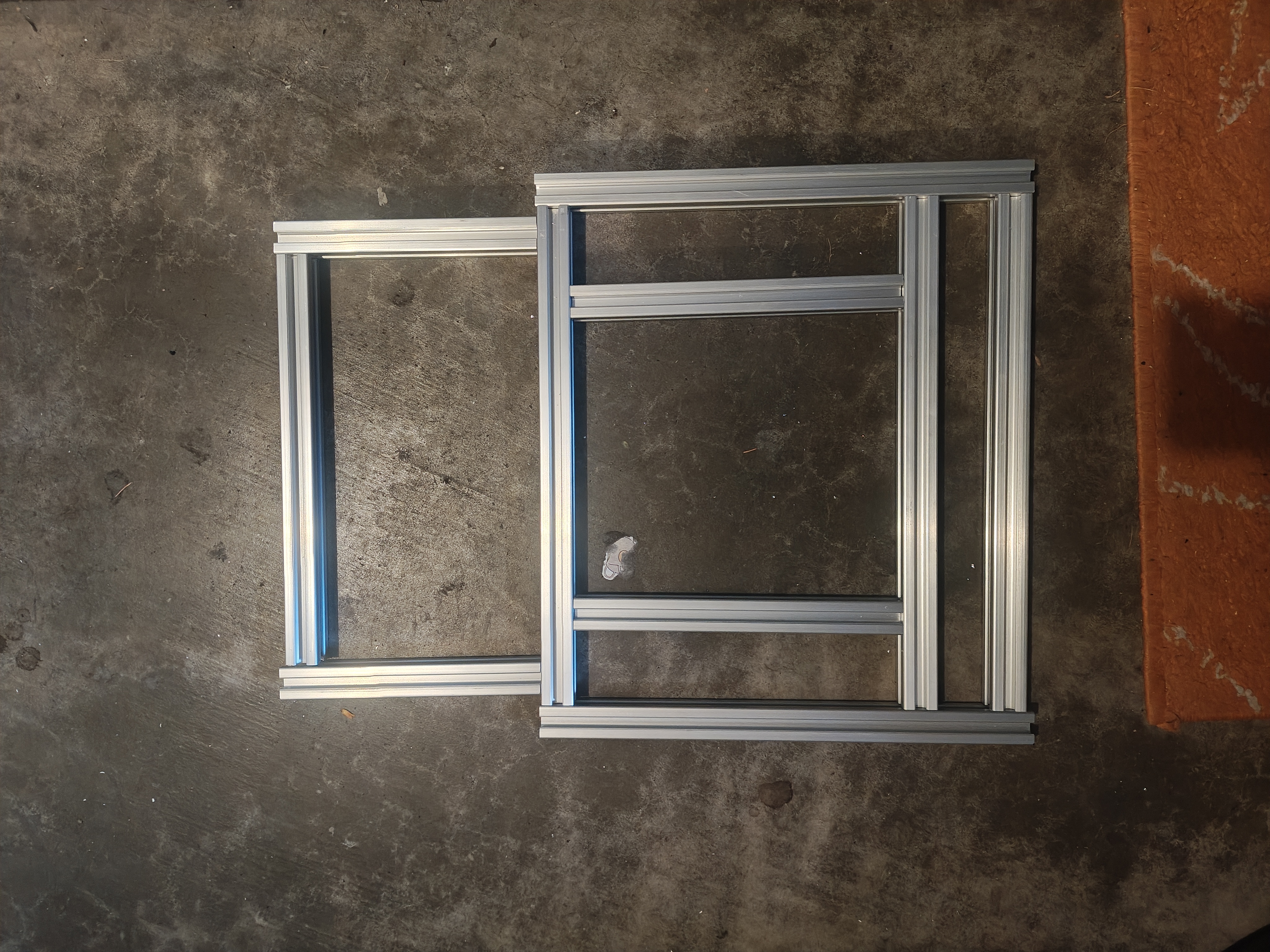 Several lengths of silver 2020 aluminum extrusion laid out on a workbench