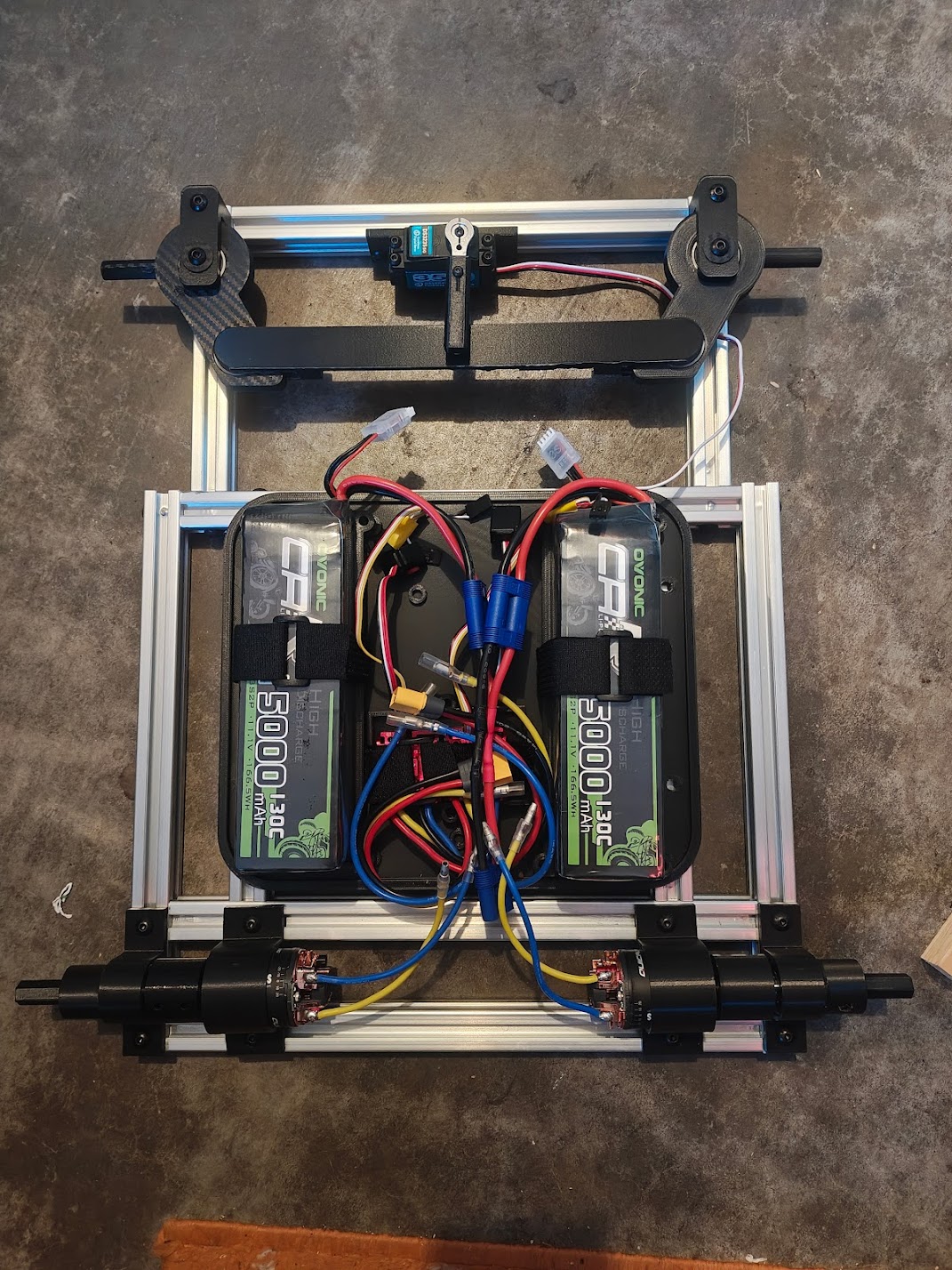 Rover frame with steering linkage, motors, and electronics box assembled but no wheels attached